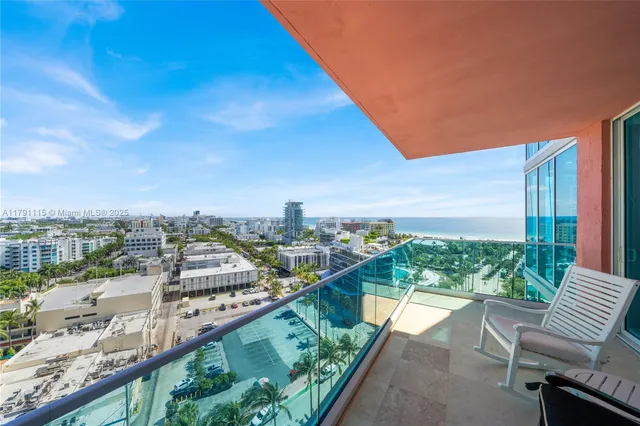 a view of a city from a balcony with outdoor seating