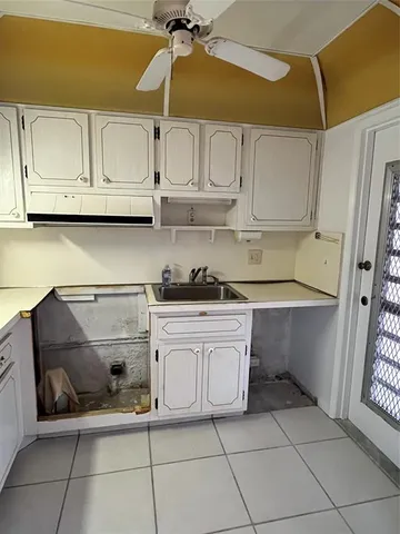 a kitchen with white cabinets and white appliances