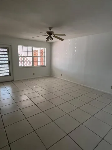 a view of a livingroom with a chandelier fan and windows