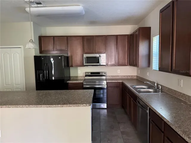 a kitchen with granite countertop stainless steel appliances and wood cabinets