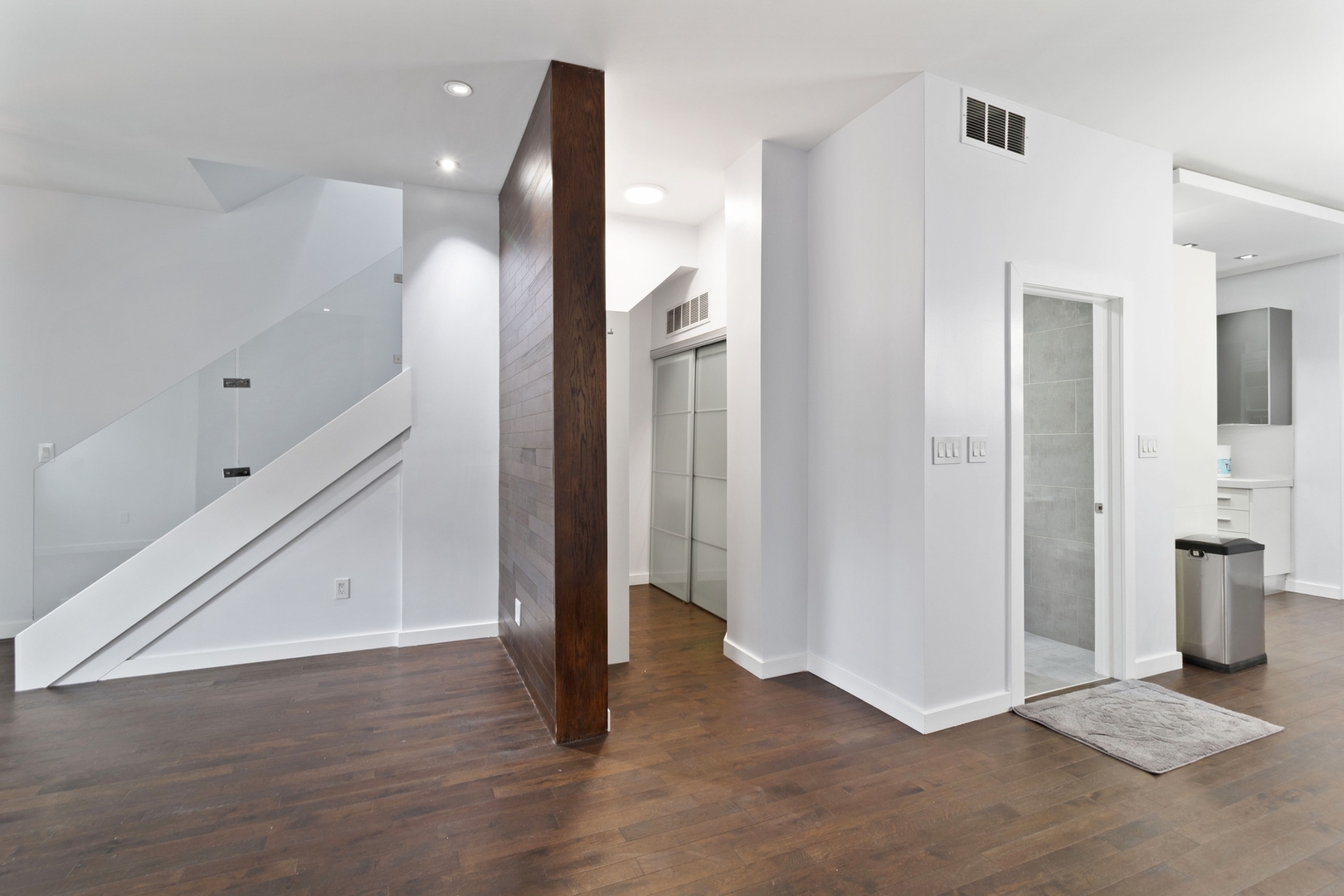 Undisclosed Address Chicago, IL 60607 - Photo 3 of 17 an empty room with wooden floor and a bathroom
