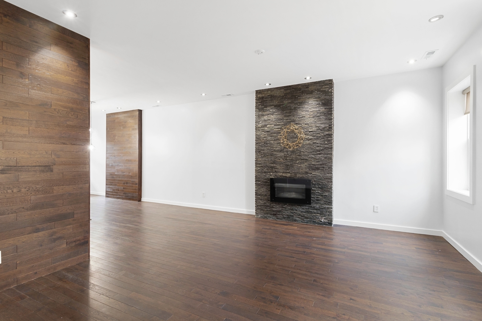 Undisclosed Address Chicago, IL 60607 - Photo 4 of 17 a view of an empty room with wooden floor and a fireplace