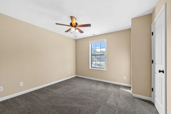 a view of a room with a ceiling fan and a window