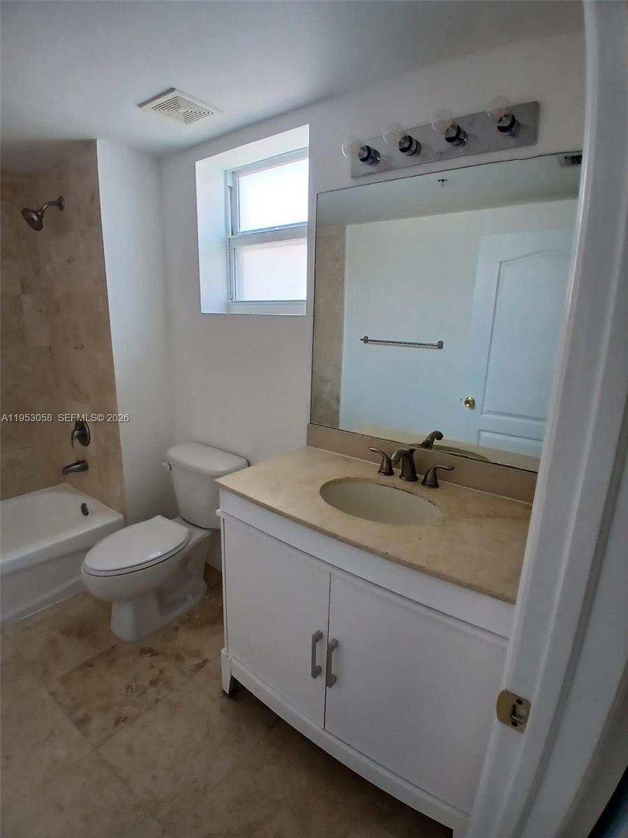 425 Northeast 30th Street, Unit 202 Miami, FL 33137 - Photo 5 of 11 a bathroom with a granite countertop toilet sink and mirror