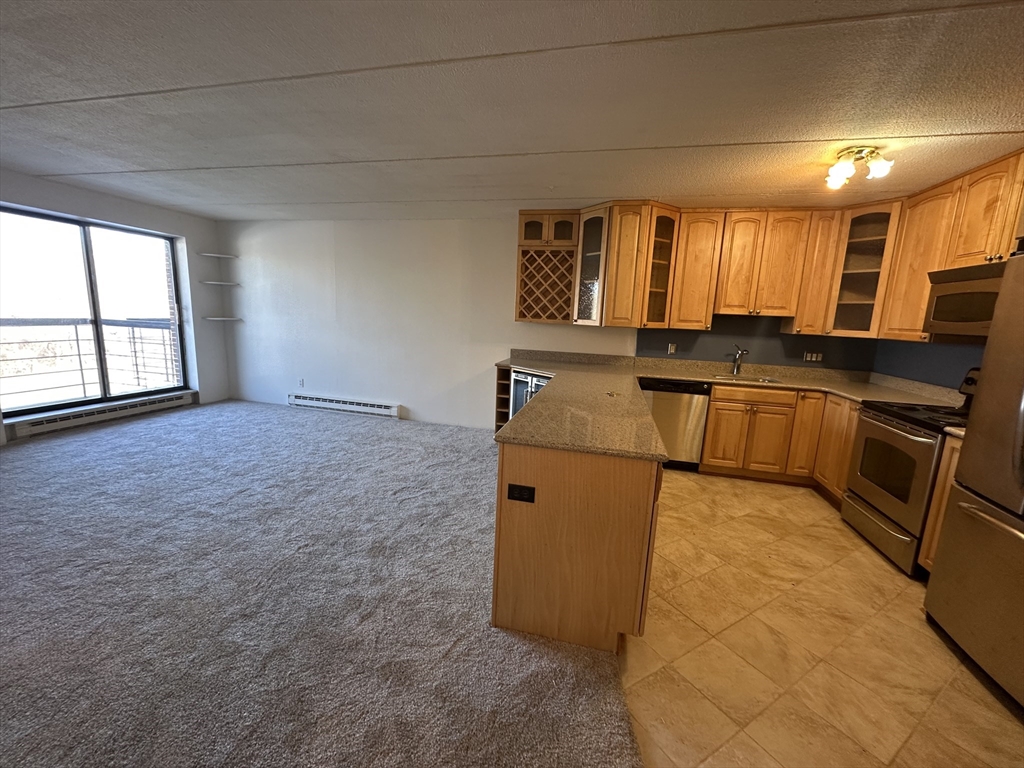 46 Cochituate Road, Unit 408 Framingham, MA 01701 - Photo 4 of 22 a kitchen with stainless steel appliances granite countertop a sink stove and cabinets