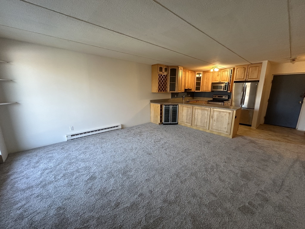 46 Cochituate Road, Unit 408 Framingham, MA 01701 - Photo 8 of 22 a view of a kitchen with a refrigerator and a stove