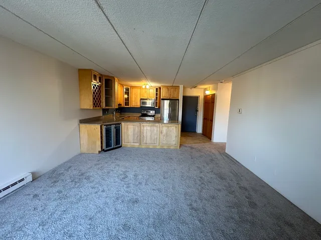 a view of a kitchen with a sink stove cabinets and empty room