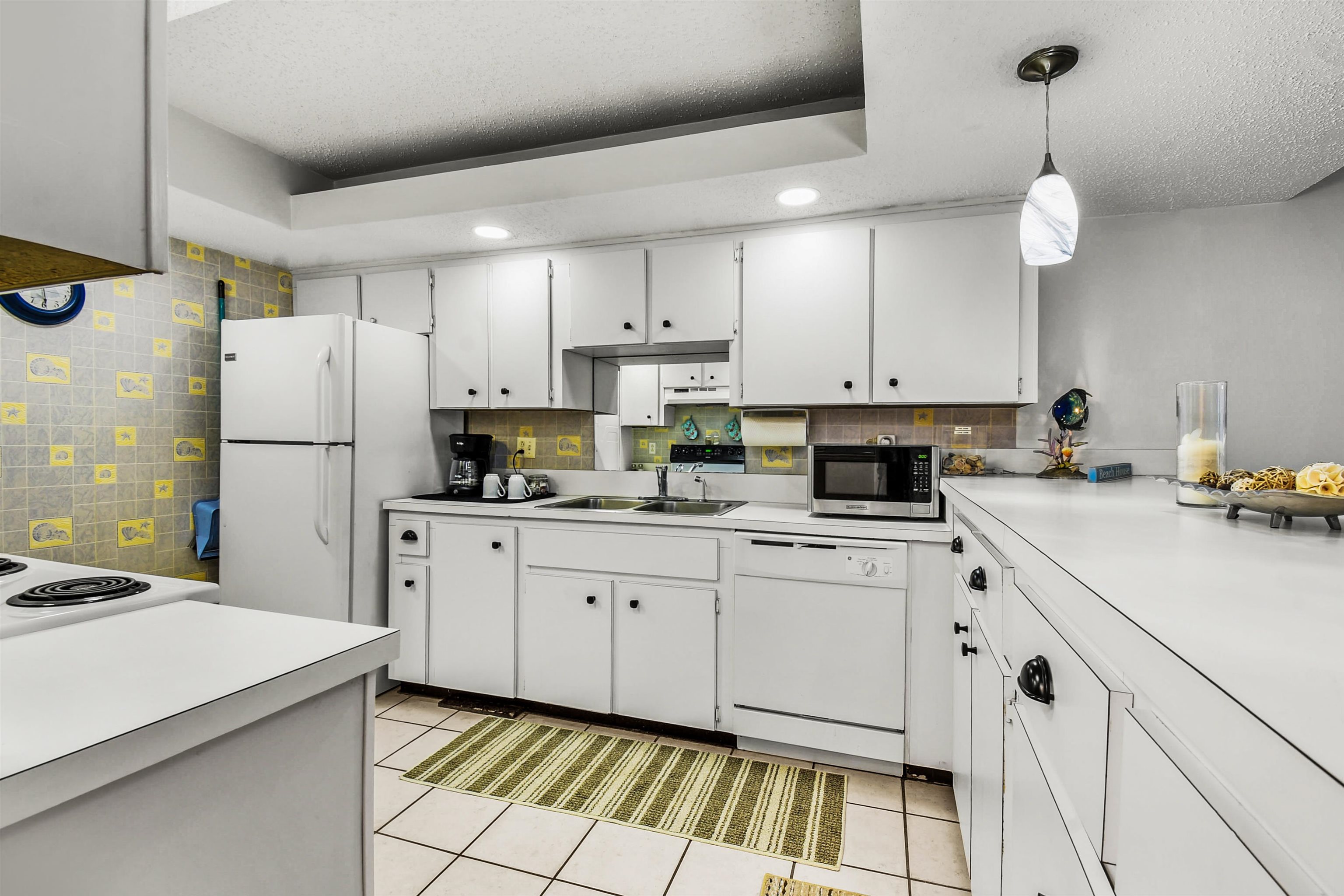 2 Dondanville Road, Unit 212 St. Augustine, FL 32080 - Photo 13 of 31 a kitchen with white cabinets and stainless steel appliances