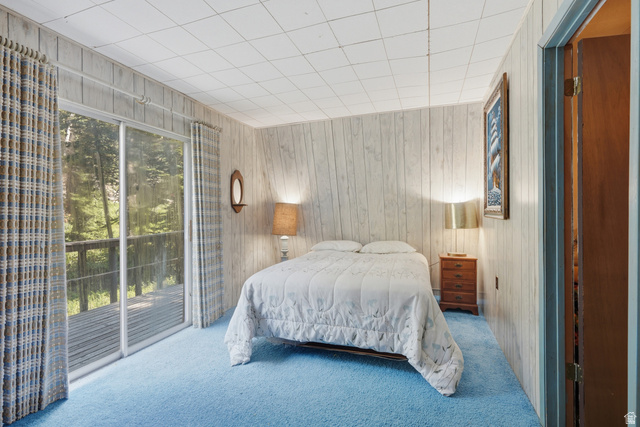 8505 South Snake Crk Road Salt Lake City, UT 84121 - Photo 33 of 67 Room featuring wood-paneled walls, blue carpeting, and a white grid ceiling