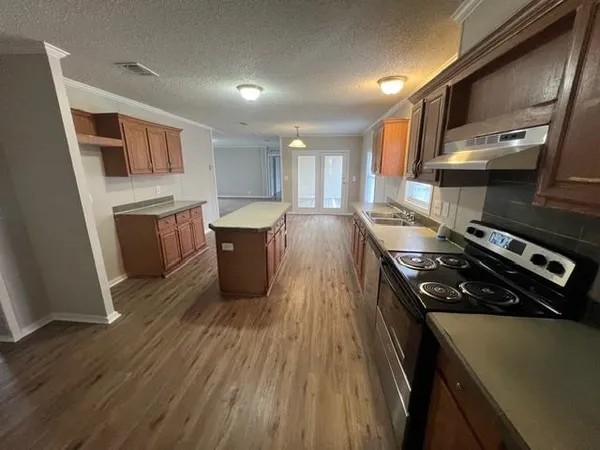 a kitchen with a stove a sink and a refrigerator
