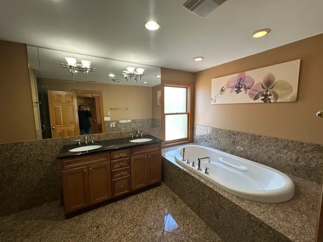 a large bathroom with a large tub a sink and a mirror