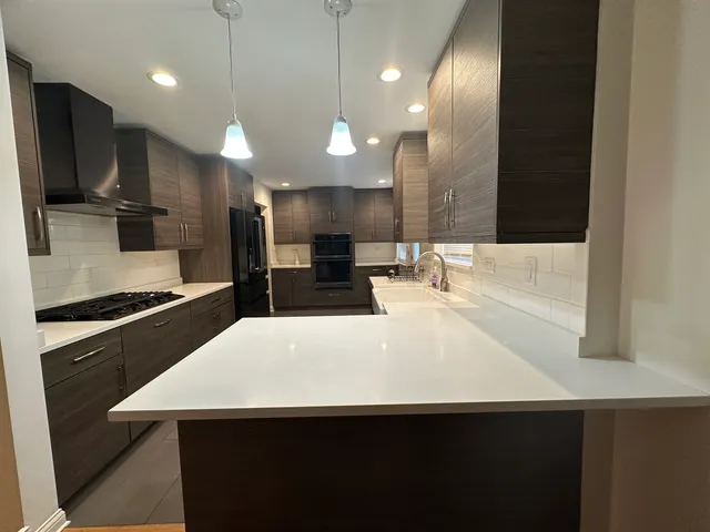 a kitchen with kitchen island a sink stainless steel appliances and cabinets