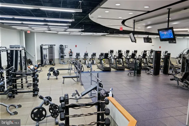 a room with gym equipment and pool table