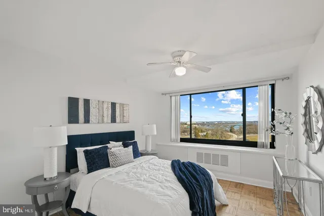 a bedroom with a large bed and a large window with outer view