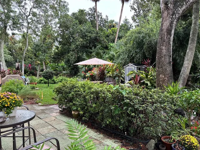 a view of a backyard with sitting area and garden