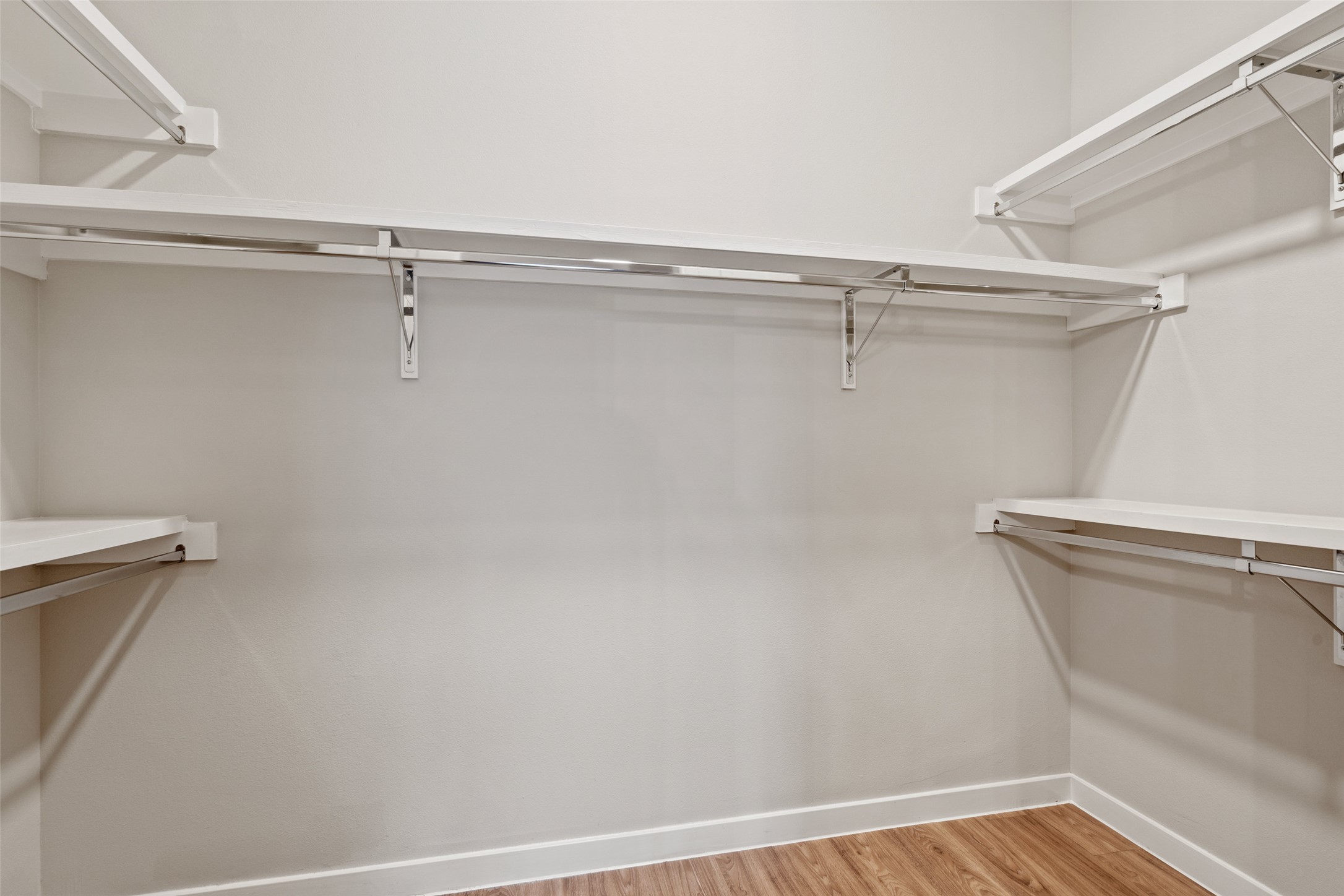 4510 Terry-O Lane, Unit 341 Austin, TX 78745 - Photo 30 of 40 The property features a closet with built-in shelving and hanging rods, light-colored walls, and wood-look flooring
