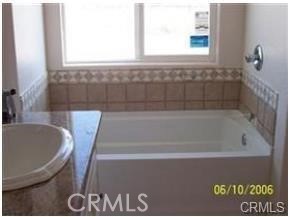 15542 Kiamichi Road Apple Valley, CA 92307 - Photo 24 of 39 a bath tub sitting in a bathroom next to a window
