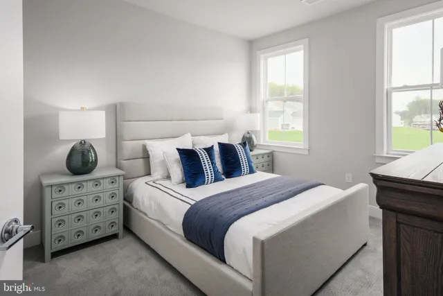 a bedroom with a bed and two windows