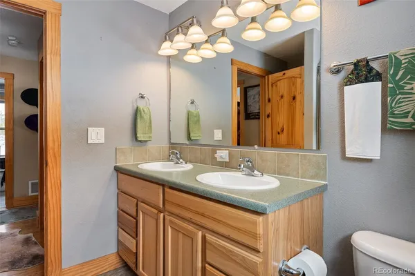 a bathroom with a sink a light fixture and a mirror