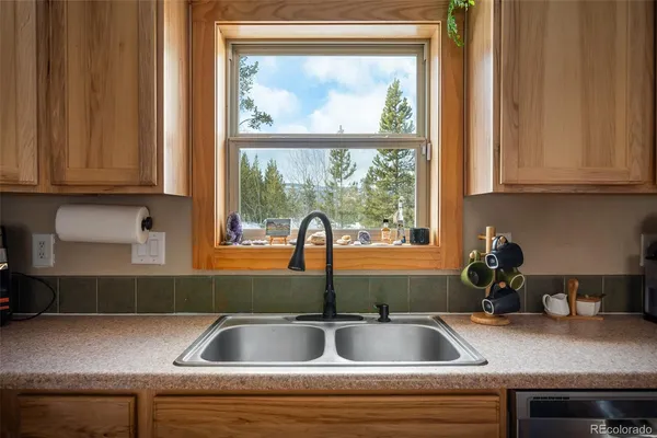 a kitchen sink with a granite countertop window and sink