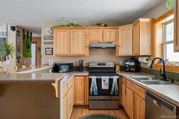 a kitchen with stainless steel appliances granite countertop a stove a sink and a white cabinets
