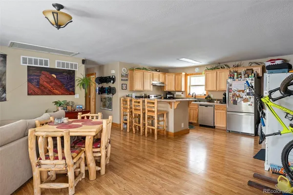 a view of a dining room with furniture a kitchen and chandelier
