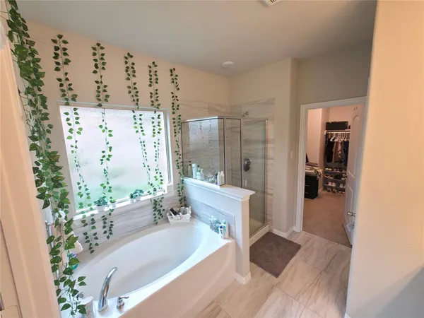 a spacious bathroom with a tub shower and a large mirror