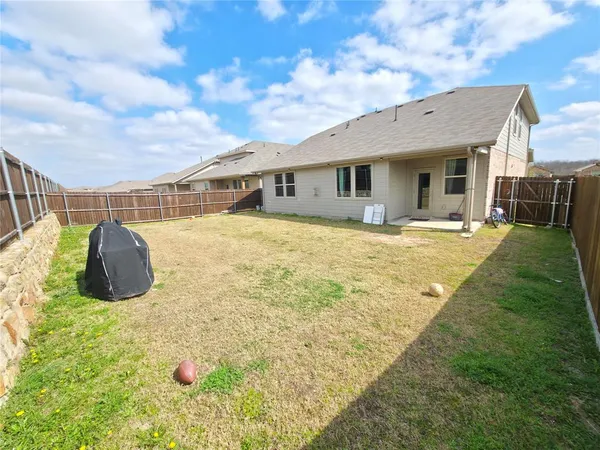 a view of a house with a backyard and a tree