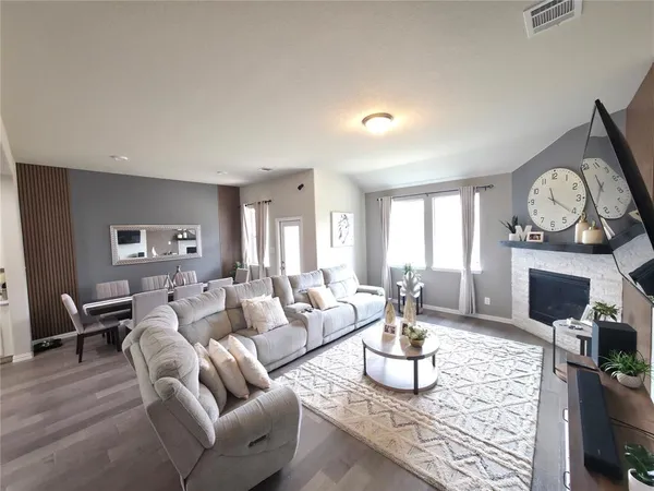 a living room with furniture a fireplace and a large window