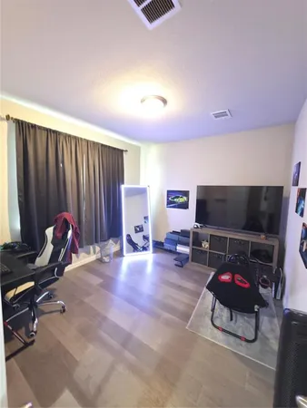 a living room with furniture a flat screen tv and a couch