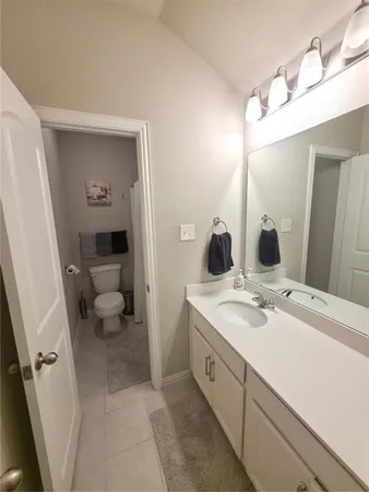 a spacious bathroom with a sink a toilet and a mirror