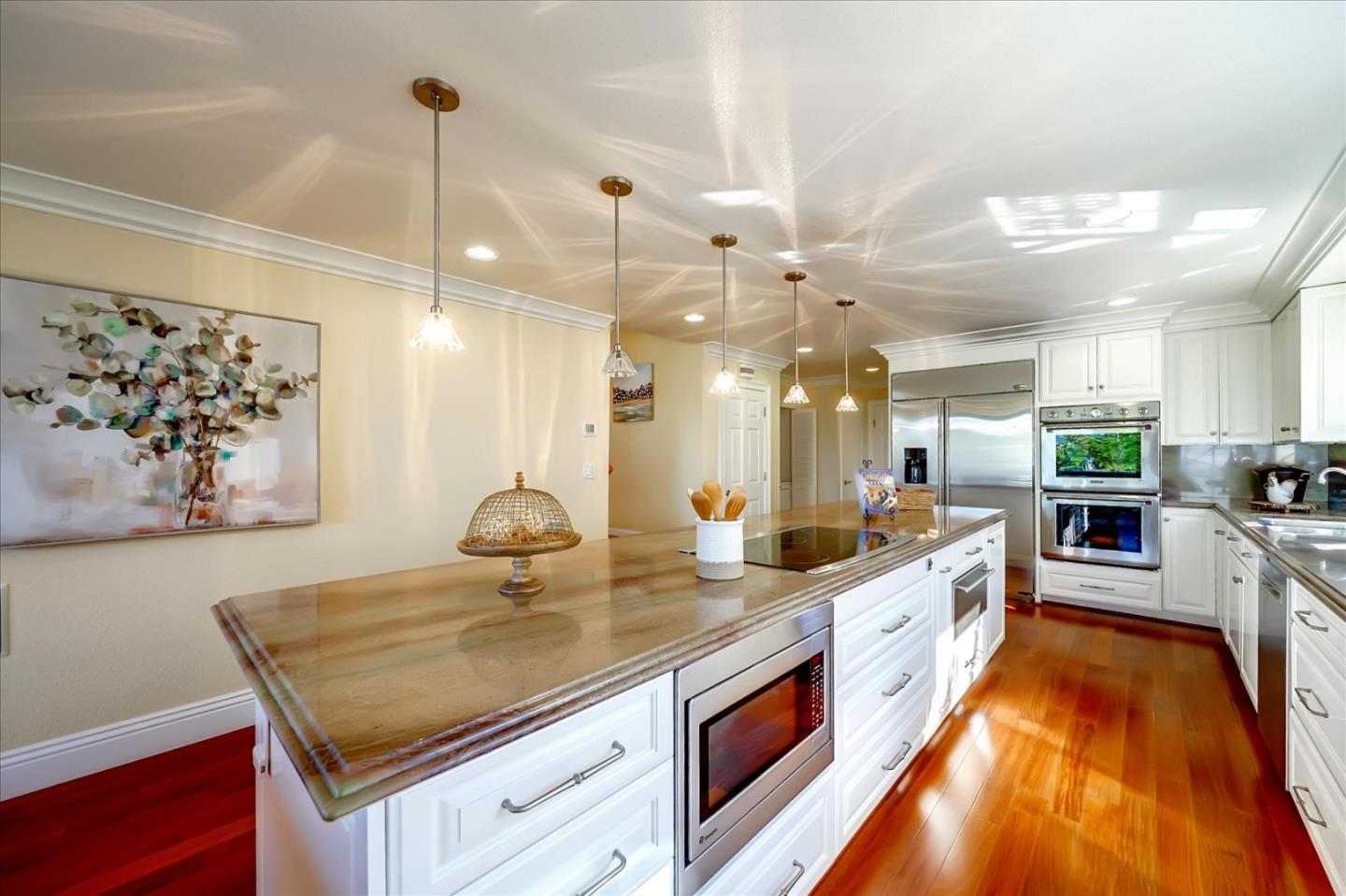 475 Winged Foot Road Half Moon Bay, CA 94019 - Photo 13 of 28 a kitchen with stainless steel appliances granite countertop a sink a stove and a wooden floors