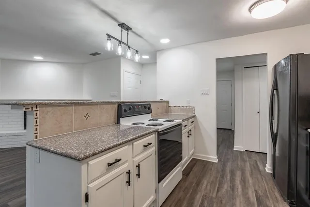 a kitchen with a stove and a wooden floor