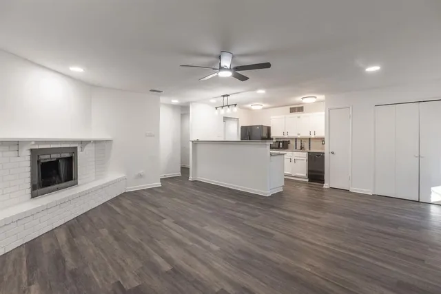 an open kitchen with a refrigerator and a fireplace