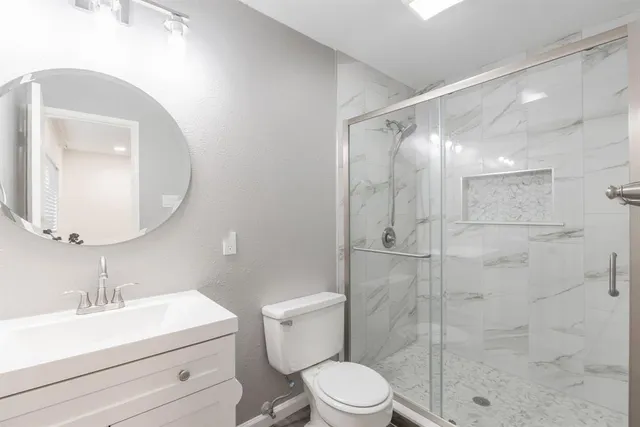 a bathroom with a sink a toilet and shower