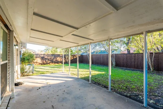 a view of a yard with porch and wooden fence