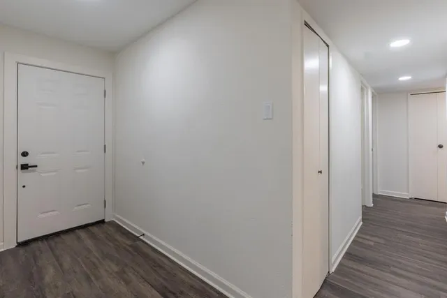 a view of a hallway with wooden floor