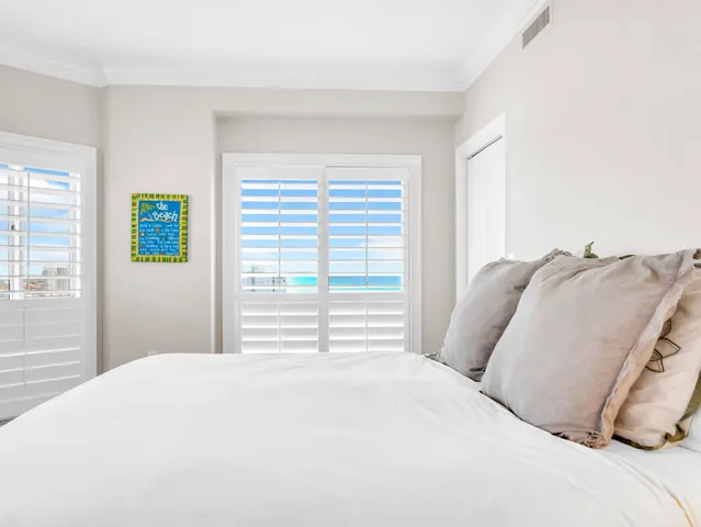 a bedroom with a large bed and a chandelier