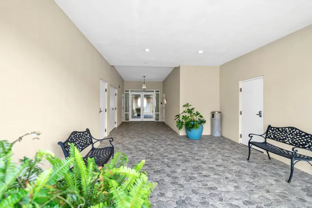a kitchen with granite countertop a refrigerator and white cabinets
