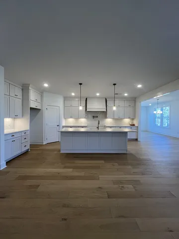 a view of kitchen with kitchen island wooden floor and center island