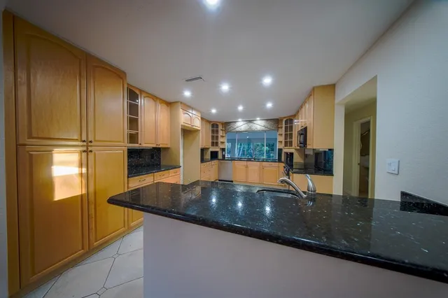 a bathroom with a granite countertop sink a toilet and shower