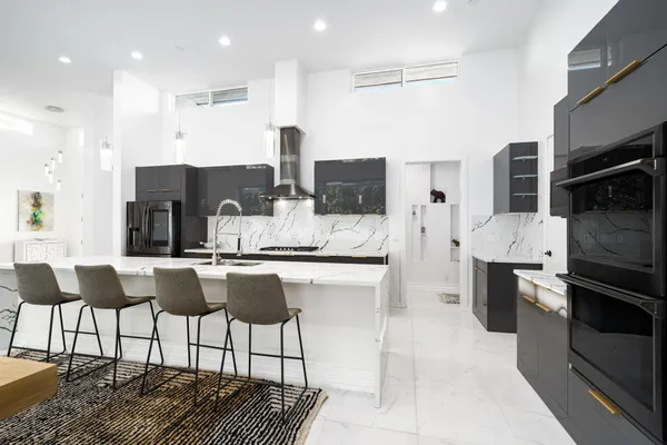 a kitchen with stainless steel appliances kitchen island granite countertop a stove and cabinets