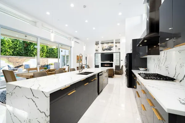 a large kitchen with kitchen island a large counter top space appliances and a counter top space