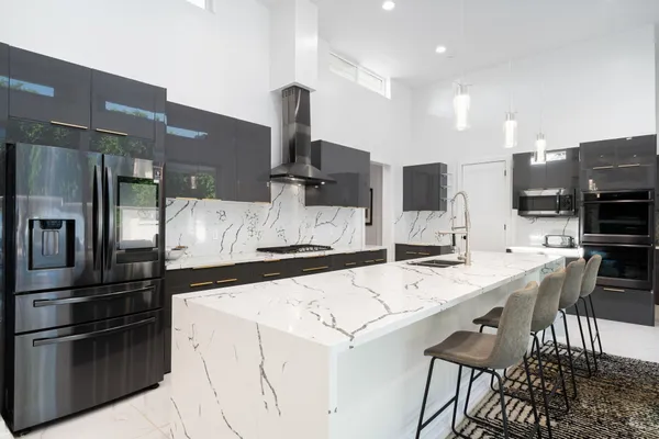 a kitchen with stainless steel appliances granite countertop a sink stove and refrigerator