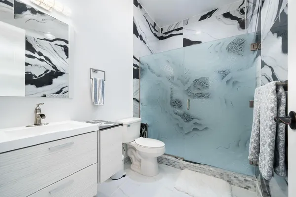 a bedroom with a bed and a flat tv screen on the dresser