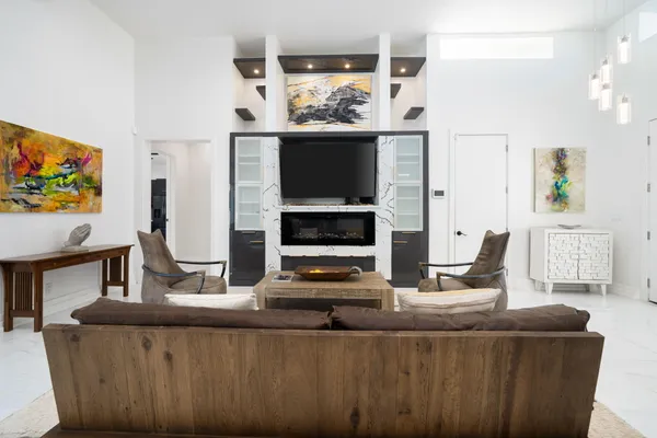 a living room with furniture a flat screen tv and a fireplace