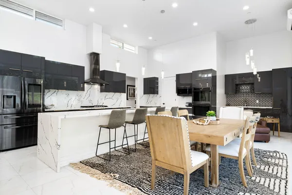 a kitchen with stainless steel appliances kitchen island granite countertop a sink and a refrigerator