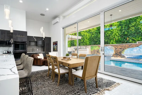 a dining room with furniture a rug and a floor to ceiling window