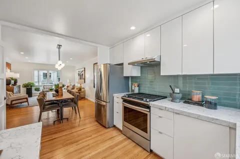 a kitchen with granite countertop a sink stove and cabinets