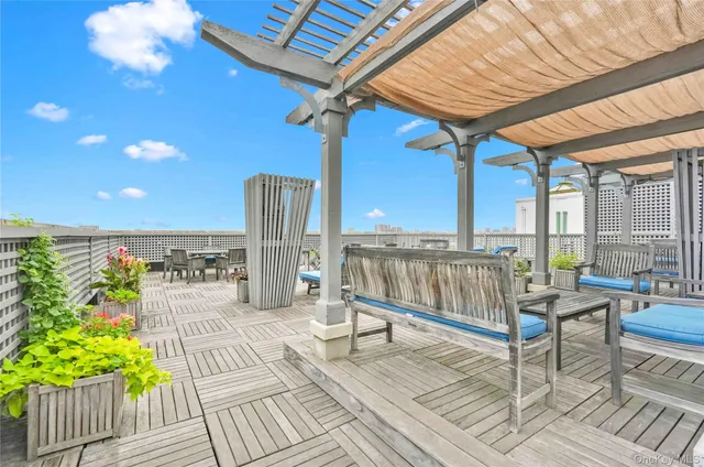a view of a roof deck with table and chairs barbeque with wooden floor and fence